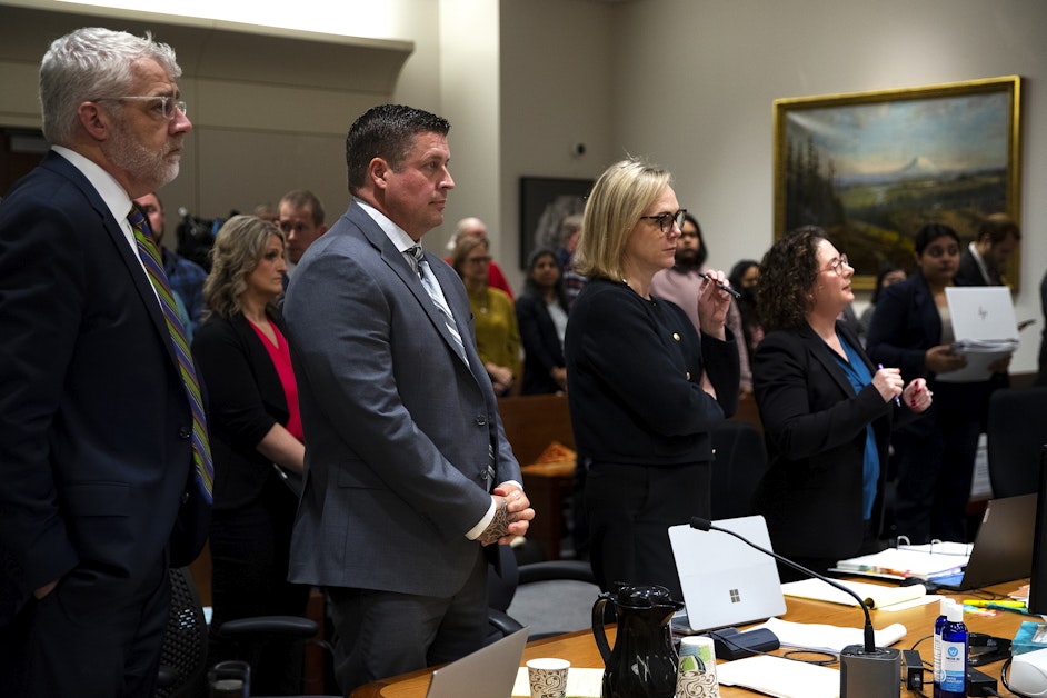 Jeffrey Nelson standing between his defense attorneys Tim Leary and Emma Scanlan in court as Judge Nicole Gaines Phelps enters the courtroom during his trial on May 22, 2024.