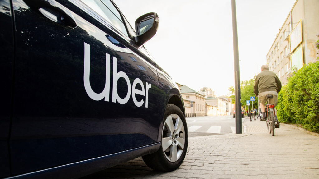 The Uber logo displayed above a trading post on the New York Stock Exchange trading floor.